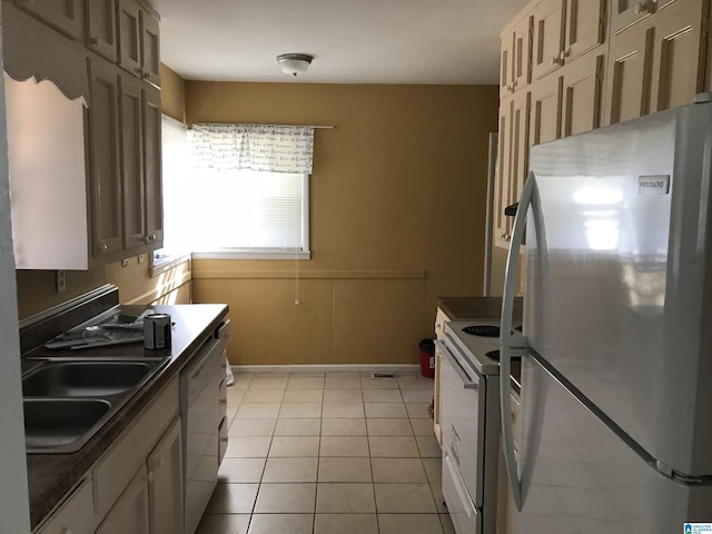 kitchen with sink, light tile patterned floors, and white appliances