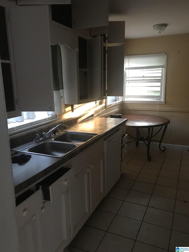 kitchen with white cabinetry, white dishwasher, light tile patterned flooring, and sink