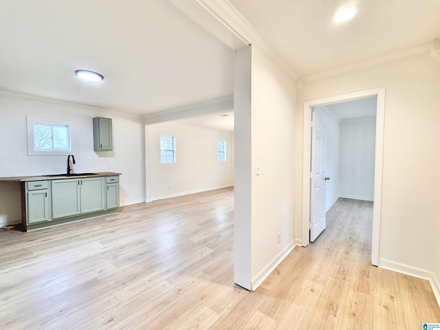 interior space featuring ornamental molding, plenty of natural light, sink, and light hardwood / wood-style flooring