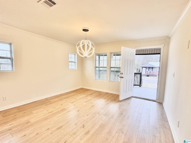 spare room featuring crown molding, light hardwood / wood-style flooring, and a chandelier