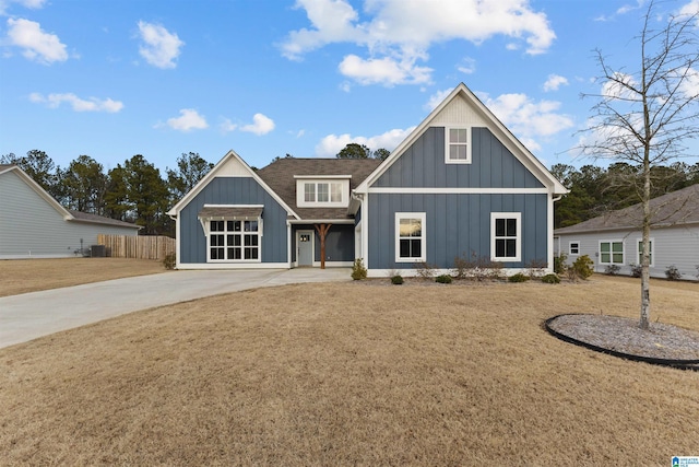 view of front of property featuring fence, a front lawn, board and batten siding, and roof with shingles