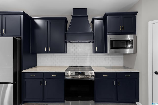 kitchen featuring light stone counters, appliances with stainless steel finishes, custom range hood, and backsplash