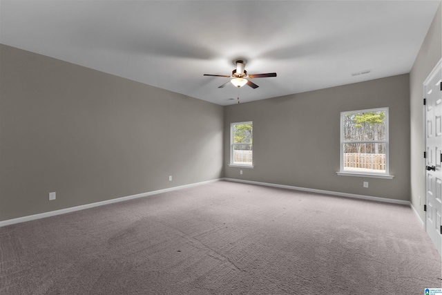 carpeted spare room featuring ceiling fan