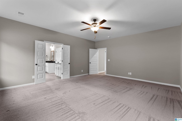 unfurnished bedroom featuring light carpet, ceiling fan, and ensuite bathroom