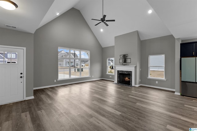 unfurnished living room with dark wood-type flooring, ceiling fan, and high vaulted ceiling