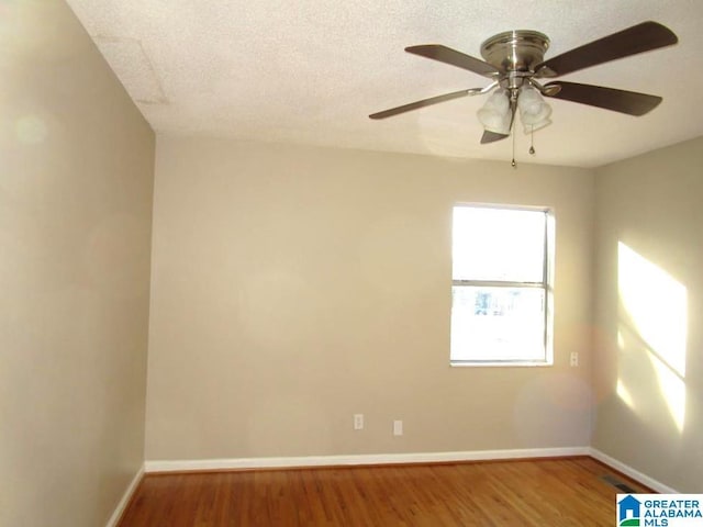 empty room featuring hardwood / wood-style flooring, ceiling fan, and a textured ceiling