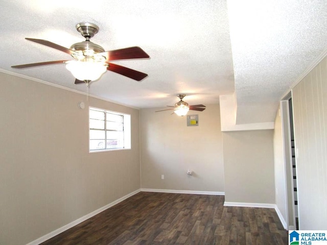 empty room with dark wood-type flooring, crown molding, and a textured ceiling