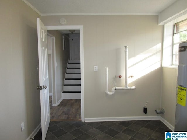 washroom featuring ornamental molding, water heater, and dark tile patterned floors