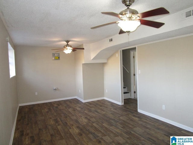 spare room featuring dark hardwood / wood-style flooring, ceiling fan, and a textured ceiling