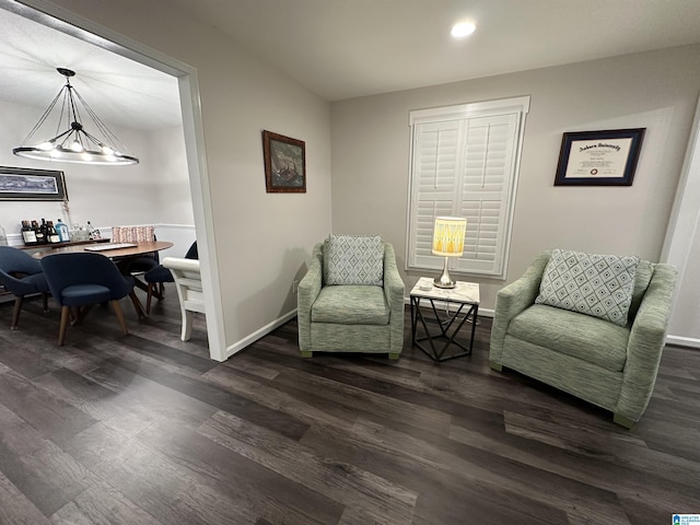 living area with an inviting chandelier and dark hardwood / wood-style flooring