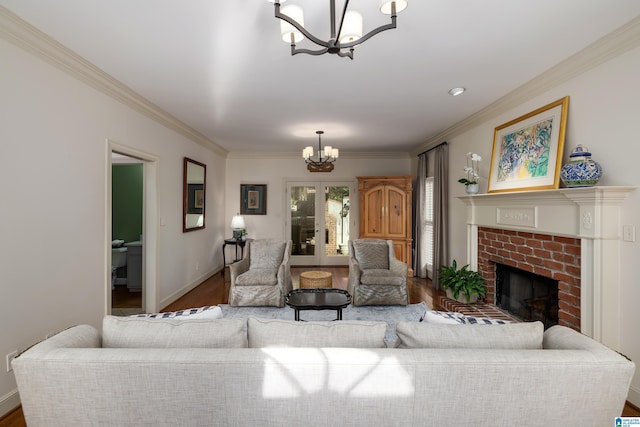 living room with dark wood-type flooring, french doors, an inviting chandelier, crown molding, and a fireplace