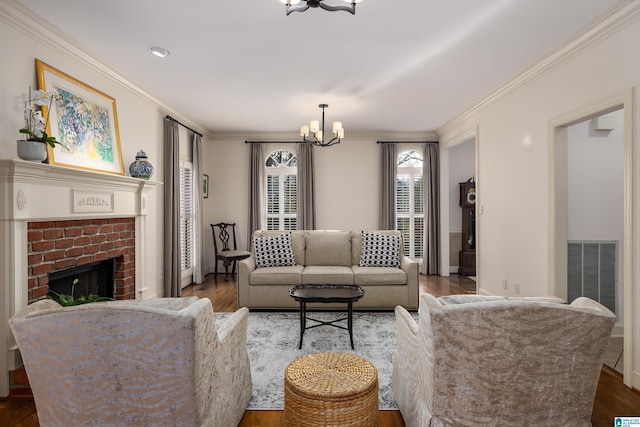 living room with crown molding, dark wood-type flooring, a chandelier, and a fireplace