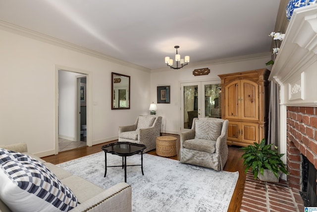 living room featuring hardwood / wood-style floors, a fireplace, a chandelier, crown molding, and french doors