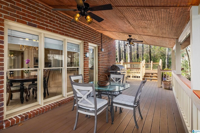 wooden deck featuring a grill, covered porch, and ceiling fan