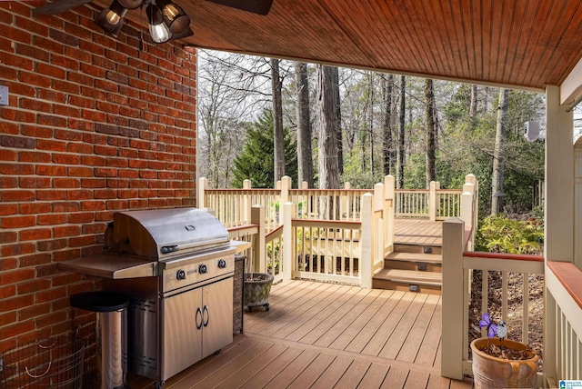 wooden terrace featuring area for grilling and ceiling fan