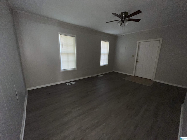 unfurnished room featuring dark wood-type flooring, ceiling fan, and ornamental molding