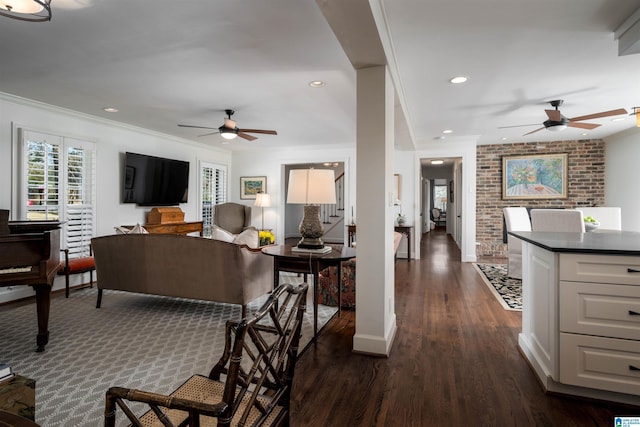 living room with ornamental molding, brick wall, ceiling fan, and dark hardwood / wood-style flooring