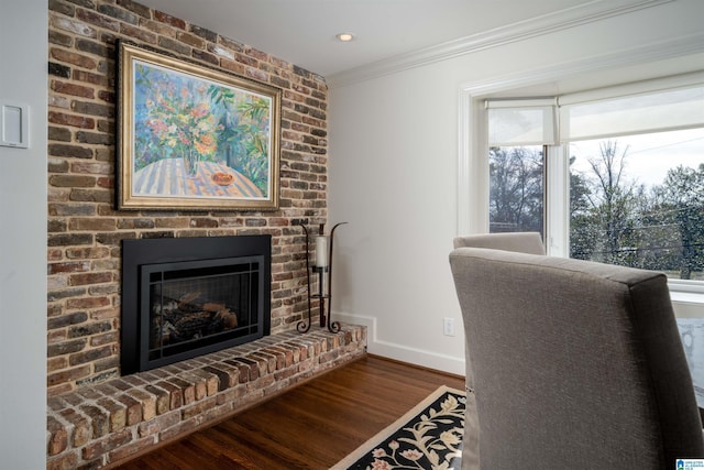 interior space with a fireplace, ornamental molding, and dark hardwood / wood-style floors