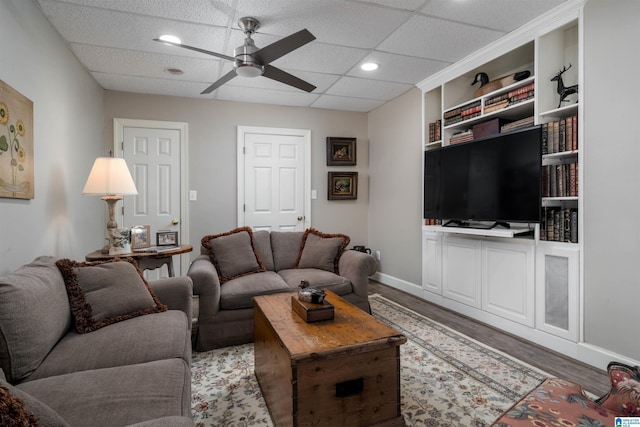 living room with ceiling fan, a paneled ceiling, and hardwood / wood-style floors