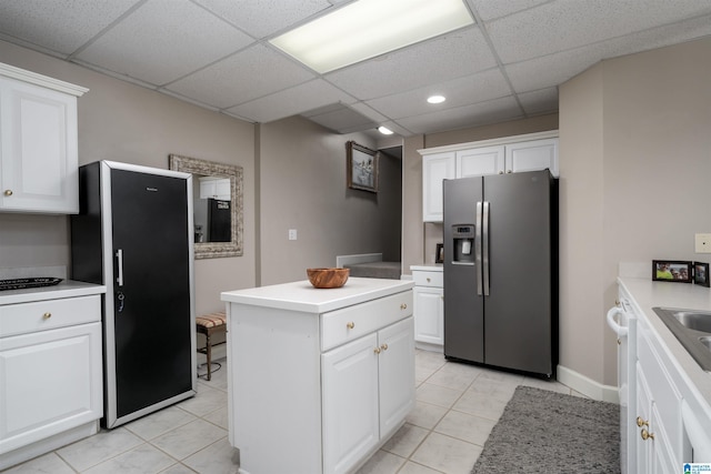 kitchen featuring white cabinetry, stainless steel fridge with ice dispenser, black refrigerator, and a center island