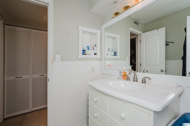 bathroom with tile patterned floors, tile walls, and vanity