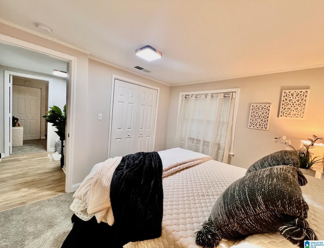 carpeted bedroom featuring crown molding and a closet