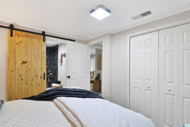 bedroom with crown molding, a barn door, and a closet