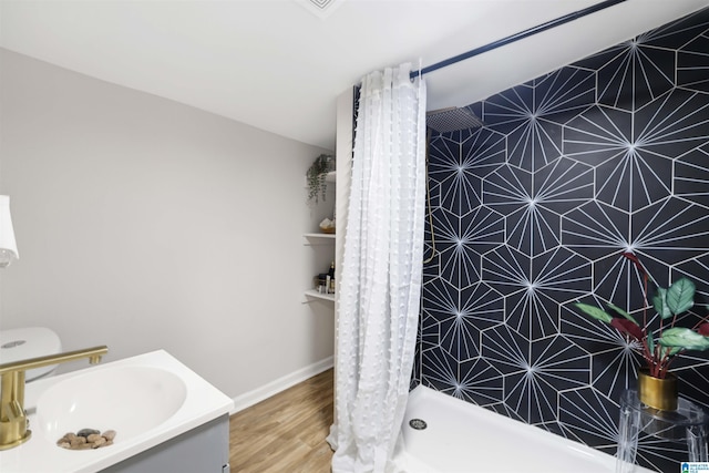 bathroom with hardwood / wood-style floors, vanity, and curtained shower