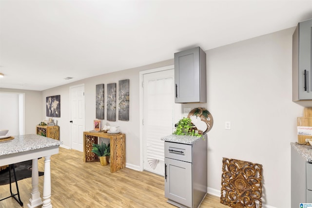 kitchen with light hardwood / wood-style flooring and gray cabinets