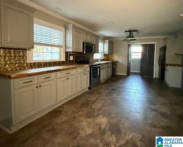 kitchen with stainless steel appliances, white cabinets, crown molding, and tasteful backsplash