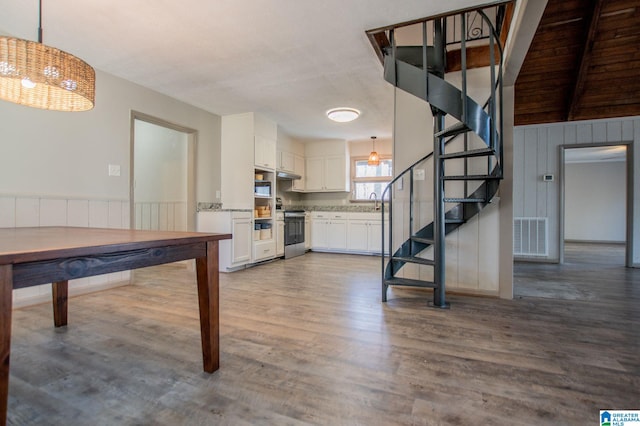 kitchen featuring white cabinetry, stainless steel range, decorative light fixtures, and dark hardwood / wood-style floors