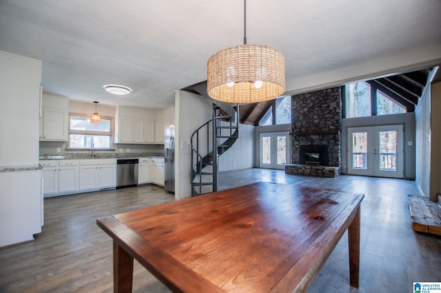 dining area with dark hardwood / wood-style flooring, sink, vaulted ceiling, and french doors