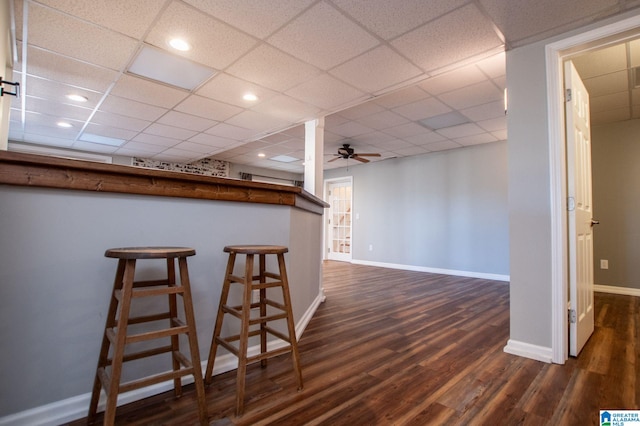 interior space featuring dark wood-type flooring, ceiling fan, and a paneled ceiling