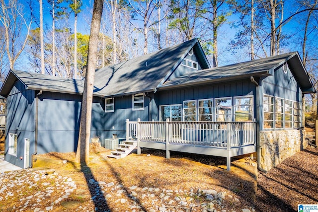 back of property with central AC, a deck, and a sunroom