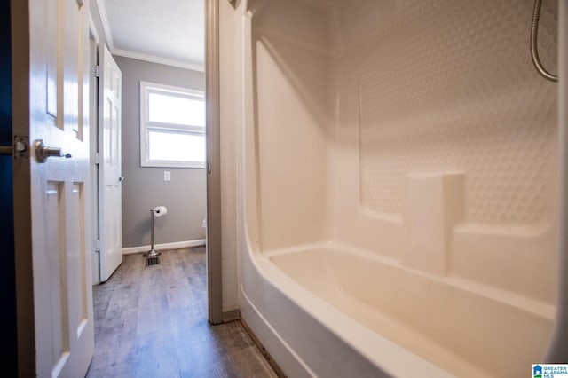 bathroom with ornamental molding,  shower combination, and hardwood / wood-style floors