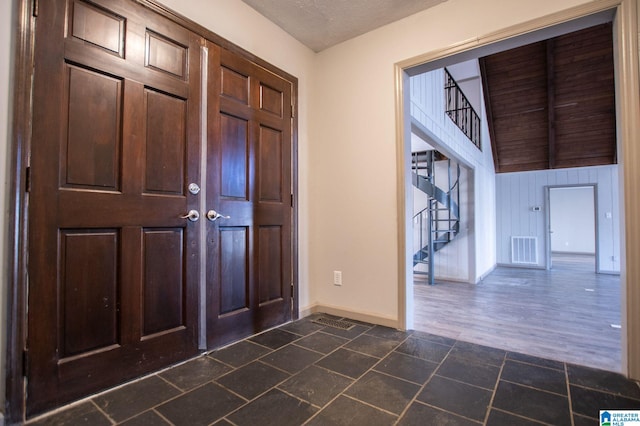 foyer entrance with a textured ceiling and dark hardwood / wood-style flooring