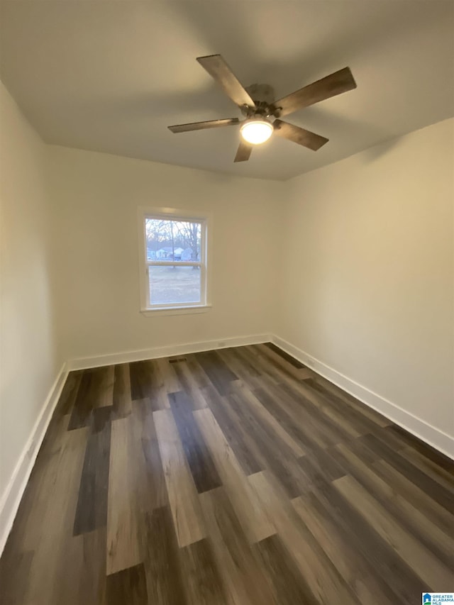 empty room with ceiling fan and dark wood-type flooring