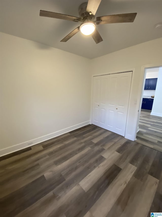 unfurnished bedroom featuring ceiling fan, a closet, and dark hardwood / wood-style flooring