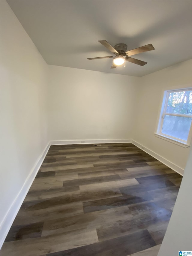 empty room featuring dark hardwood / wood-style flooring and ceiling fan