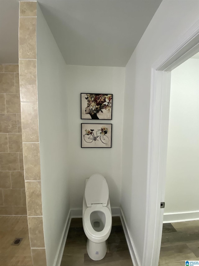 bathroom with toilet and hardwood / wood-style floors