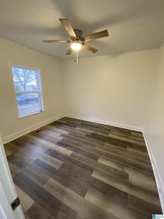 unfurnished room with ceiling fan and dark wood-type flooring