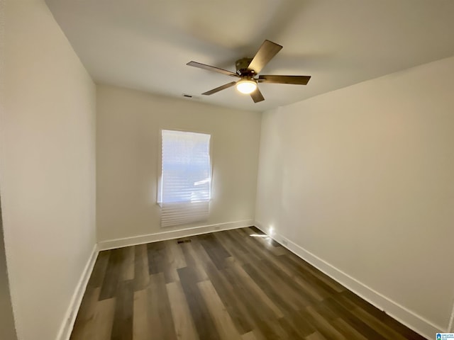 spare room featuring ceiling fan and dark wood-type flooring