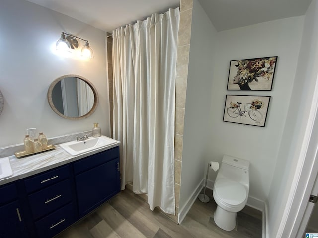 bathroom featuring toilet, hardwood / wood-style flooring, walk in shower, and vanity