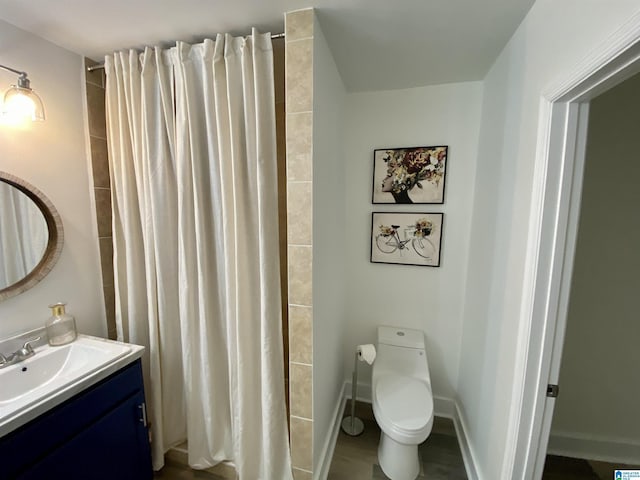 bathroom with hardwood / wood-style flooring, vanity, a shower with curtain, and toilet