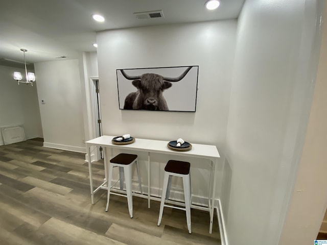 interior space with hardwood / wood-style flooring, hanging light fixtures, and a notable chandelier