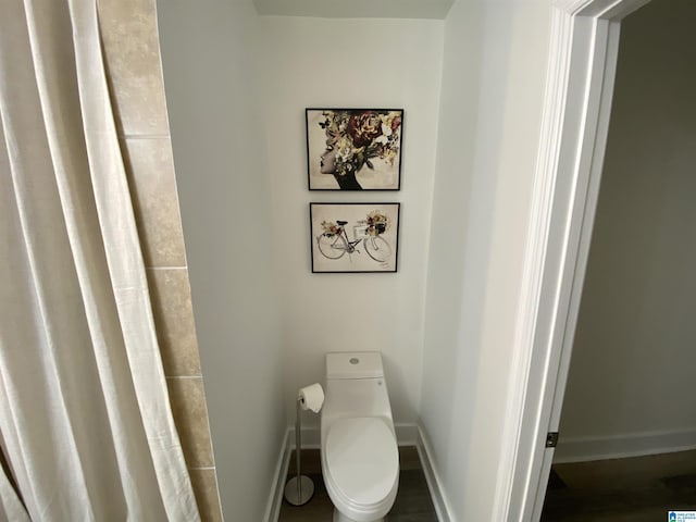 bathroom featuring toilet and wood-type flooring