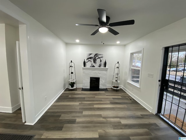 workout area featuring ceiling fan, a high end fireplace, and dark hardwood / wood-style flooring