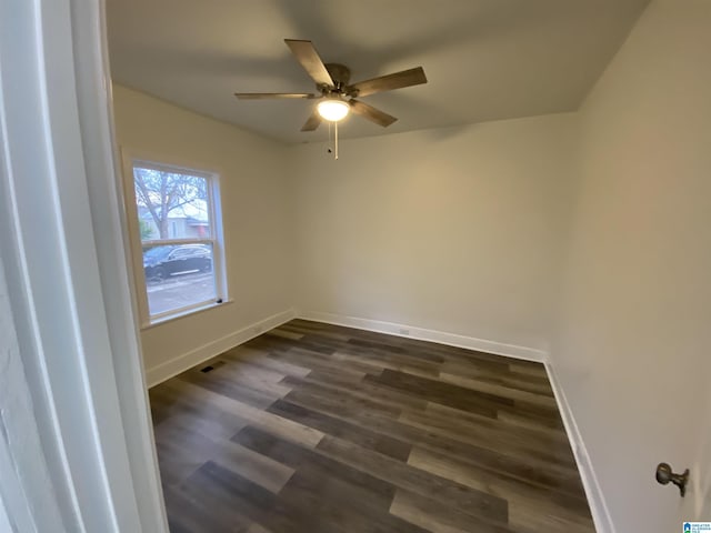 empty room with ceiling fan and dark hardwood / wood-style flooring