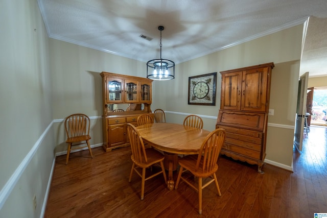 dining space featuring ornamental molding, dark hardwood / wood-style floors, and a chandelier