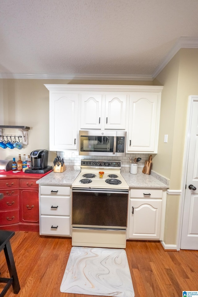 kitchen with light hardwood / wood-style flooring, ornamental molding, white range with electric cooktop, decorative backsplash, and white cabinets